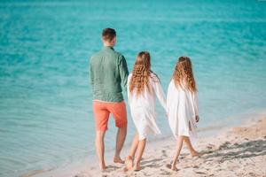 Father and little kids on the beach photo