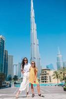 familia feliz caminando en dubai con rascacielos en el fondo. foto