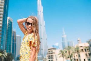 Happy girl walking in Dubai with skyscraper in the background. photo