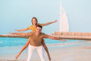 Beautiful father and daughter at the beach enjoying summer vacation. photo