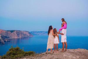 familia feliz de cuatro personas caminando por las montañas al atardecer foto