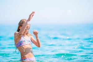 Cute little girl at beach during summer vacation photo