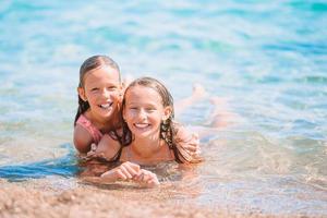 Adorable little girls having fun on the beach photo