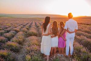 Family in lavender flowers field at sunset in white dress and hat photo