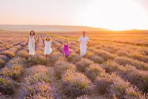 Family in lavender flowers field on the sunset photo