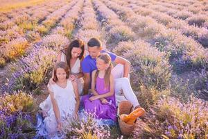 familia en el campo de flores de lavanda al atardecer con vestido blanco y sombrero foto