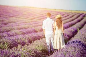 Family in lavender flowers field at sunset in white dress and hat photo