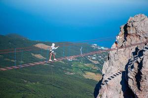 chicas cruzando el abismo en el puente de cuerda. fondo del mar negro, crimea, rusia foto