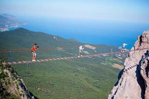 familia cruzando el abismo en el puente de cuerda. fondo del mar negro, crimea, rusia foto