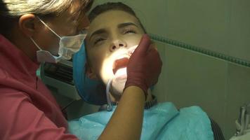 young beautiful woman at the dentist treats her teeth video