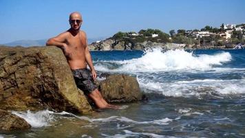 un' giovane bello uomo su un' roccioso spiaggia video