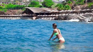 jeune fille gaie nage dans la plage rocheuse sauvage video