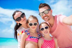 Young beautiful family taking selfie on the beach photo