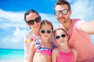 Young beautiful family taking selfie on the beach photo