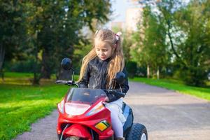 niña adorable en su motocicleta de juguete foto