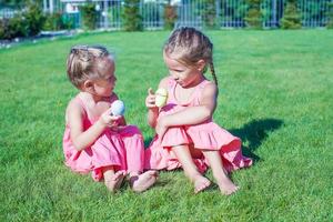 Adorable little girls having fun with Easter Eggs on green grass photo