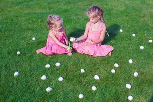 adorables niñas jugando con huevos de pascua en hierba verde foto