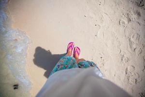 primer plano del pie de una mujer en las pizarras en la playa de arena foto