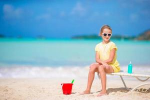 Adorable little girl playing with toys on beach vacation. Kid play with sand photo