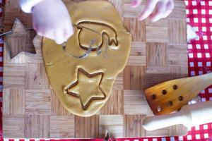 Child hands making from dough gingerbread man photo