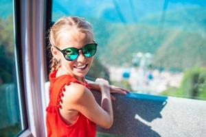 adorable niña en la cabina del teleférico en las montañas