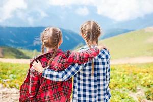 Beautiful happy little girls in mountains in the background of fog photo