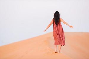 chica entre dunas en el desierto en emiratos árabes unidos