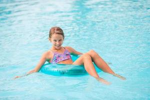 Little adorable girl in outdoor swimming pool photo