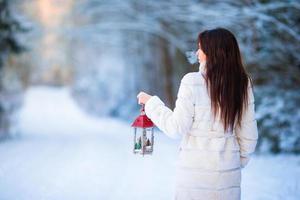Winter beauty. Woman holding Christmas lantern outdoors on beautiful winter snow day photo