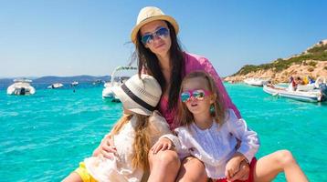 Little girls resting with happy mother on a big boat photo