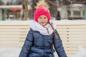 Adorable little girl outdoor in the park on winter day photo