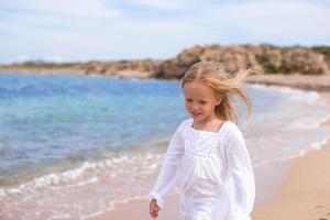 Adorable little girl at tropical beach during vacation photo