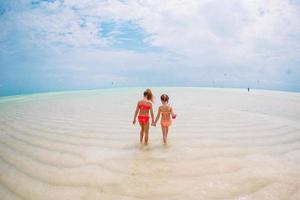Kids have a lot of fun at tropical beach playing together photo
