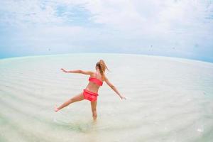 Cute little girl at beach during caribbean vacation photo