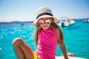 Cute little girl enjoying sailing on boat in the open sea photo