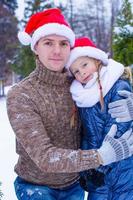 Happy family in Santa hats with christmas tree outdoor photo