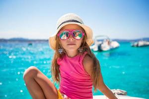 Cute little girl enjoying sailing on boat in the open sea photo