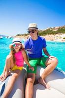 Young father with adorable girls resting on a big boat photo