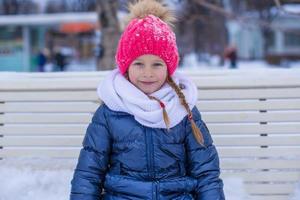 Adorable little girl outdoor in the park on winter day photo