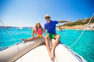 Young father with little girl resting on a big boat photo