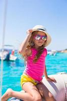 Cute little girl enjoying sailing on boat in the sea photo