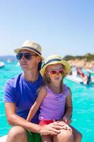 Young father with adorable girl resting on a big boat photo