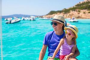 Young father with adorable girl resting on a big boat photo