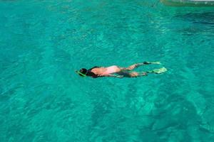 hermosa chica buceando en aguas turquesas tropicales claras foto