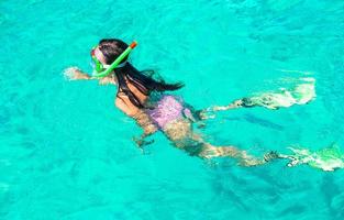 mujer joven buceando en aguas tropicales de vacaciones foto