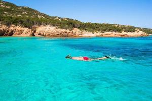 Young man snorkeling in clear tropical turquoise waters photo