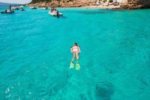 hermosa chica buceando en aguas turquesas tropicales claras foto