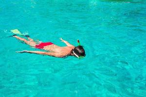 joven buceando en claras aguas turquesas tropicales foto
