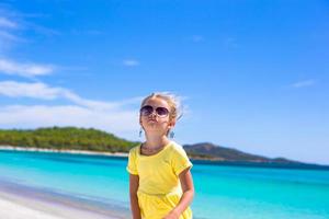 Adorable little girl have fun at tropical beach during vacation photo