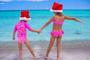 Little girls in Santa hats during summer vacation photo